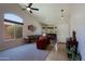 Spacious living area with large arched window, game table, and neutral carpeting at 42812 W Venture Rd, Maricopa, AZ 85138