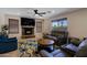 Inviting living room with a stone fireplace, ceiling fan, and comfortable seating at 42812 W Venture Rd, Maricopa, AZ 85138
