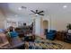 Spacious living room with modern furnishings, ceiling fan, and access to the kitchen at 42812 W Venture Rd, Maricopa, AZ 85138
