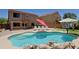 Beautiful sparkling pool with waterfall, tanning ledge, and lounge chairs in backyard at 42812 W Venture Rd, Maricopa, AZ 85138