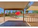 Covered patio view of a sparkling pool with tanning ledge, rock waterfall, and lounge chairs at 42812 W Venture Rd, Maricopa, AZ 85138