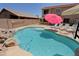 Sparkling pool with waterfall feature, lounge chairs, and backyard basketball court at 42812 W Venture Rd, Maricopa, AZ 85138
