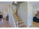 View of staircase featuring carpeted steps with white risers and wooden handrail, leading to the upper level at 42812 W Venture Rd, Maricopa, AZ 85138
