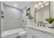 Updated bathroom showcasing decorative mirror, modern vanity, and shower over tub with tile surround at 4752 N 20Th Ave, Phoenix, AZ 85015