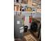 Modern laundry room featuring a large washer and dryer, water heater, and ample shelving space for storage at 4755 E Gary St, Mesa, AZ 85205