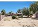 View of backyard with mature trees, sand landscaping, and fenced pool area at 4854 E Blanche Dr, Scottsdale, AZ 85254