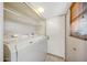 Practical laundry room with a side-by-side washer and dryer, upper cabinets, and a door at 4854 E Blanche Dr, Scottsdale, AZ 85254