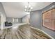 Bright living area featuring vaulted ceilings, wood-look flooring, neutral paint, and contemporary light fixture at 4854 E Blanche Dr, Scottsdale, AZ 85254