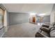 Expansive living space showcasing plush carpeting, a wooden door, and plenty of room for customized decor at 4854 E Blanche Dr, Scottsdale, AZ 85254