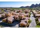 Scenic aerial view of desert townhomes with terracotta tile roofs and lush green trees, set against a beautiful mountain backdrop at 5370 S Desert Dawn Dr # 56, Gold Canyon, AZ 85118