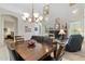 Elegant dining area featuring a chandelier, a large wood table, and views of the living room at 5370 S Desert Dawn Dr # 56, Gold Canyon, AZ 85118