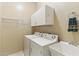 Laundry room featuring front-load washer and dryer, storage cabinets, and utility sink at 5370 S Desert Dawn Dr # 56, Gold Canyon, AZ 85118