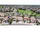This photo presents an expansive aerial view of a neighborhood filled with tile-roofed homes on a clear day at 597 S 167Th Dr, Goodyear, AZ 85338