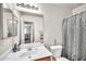 A bathroom with a large mirror, wooden cabinets, and a shower curtain at 597 S 167Th Dr, Goodyear, AZ 85338