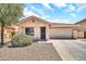 Inviting single-Gathering home featuring a two-car garage, desert landscaping, and a cozy front porch area at 597 S 167Th Dr, Goodyear, AZ 85338