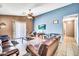 Spacious living room with a comfortable leather sofa and a large sliding glass door at 597 S 167Th Dr, Goodyear, AZ 85338