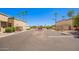 Street view of gated community showing tan homes, desert landscaping, and palm trees at 6730 E Hermosa Vista Dr # 72, Mesa, AZ 85215