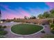 Expansive backyard featuring a manicured lawn, desert landscaping, and built-in outdoor grill for endless outdoor fun at 7415 W Lisbon Ln, Peoria, AZ 85381