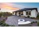 Beautiful backyard with a paved patio, fire pit, outdoor kitchen, green lawn, and lush landscaping for relaxation at 7415 W Lisbon Ln, Peoria, AZ 85381