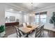 Bright and airy dining area boasts a wooden table, seating for six, stylish decor, and large windows for natural light at 7415 W Lisbon Ln, Peoria, AZ 85381