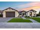 Beautifully landscaped single-story home with a paved driveway and neutral colored facade, and a two car garage at 7415 W Lisbon Ln, Peoria, AZ 85381