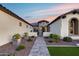 Elegant home featuring a beautiful walkway and lush landscaping leading to a covered entry and two car garage at 7415 W Lisbon Ln, Peoria, AZ 85381