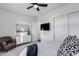Neutral bedroom features a ceiling fan, TV, ensuite bath and closet with white double doors at 7415 W Lisbon Ln, Peoria, AZ 85381