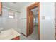 Bathroom with tiled bath and wood vanity adjacent to a bedroom entry at 829 E Echo Ln, Phoenix, AZ 85020