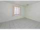 Simple bedroom space with tiled floor and a window that provides natural light at 829 E Echo Ln, Phoenix, AZ 85020