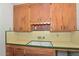 Classic kitchen featuring wood cabinets, a double basin sink, and bright yellow backsplash at 829 E Echo Ln, Phoenix, AZ 85020