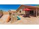 Expansive backyard with play area, dining set, and covered patio perfect for entertaining at 8319 E Portobello Ave, Mesa, AZ 85212