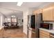 Open kitchen with stainless steel refrigerator and view into the adjacent dining and living areas at 8319 E Portobello Ave, Mesa, AZ 85212