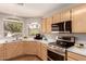 Bright kitchen featuring stainless steel appliances, light wood cabinets, and a window overlooking the backyard at 8319 E Portobello Ave, Mesa, AZ 85212