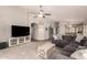 Spacious living room featuring a large sectional sofa, ceiling fan, and easy access to the kitchen area at 8319 E Portobello Ave, Mesa, AZ 85212