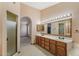 Bathroom with double sink vanity, shower, and arched doorway to the main bedroom at 8511 W Via Montoya Dr, Peoria, AZ 85383