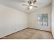 This bedroom offers neutral carpet and paint, with a ceiling fan and window providing natural light at 8511 W Via Montoya Dr, Peoria, AZ 85383