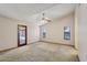 Spacious carpeted bedroom featuring a ceiling fan, a door to the patio, and two windows at 8511 W Via Montoya Dr, Peoria, AZ 85383