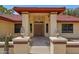 Inviting front entrance with decorative pillars, desert landscaping, and a secure screen door at 8511 W Via Montoya Dr, Peoria, AZ 85383