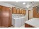 The laundry room has white appliances, a utility sink, storage and exterior door at 8511 W Via Montoya Dr, Peoria, AZ 85383