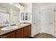 Bathroom features double sinks, a large mirror, and a door to a shower/toilet room at 942 S Deerfield Ln, Gilbert, AZ 85296