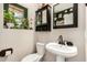 Cozy half-bathroom featuring a pedestal sink, toilet, and a quirky style at 942 S Deerfield Ln, Gilbert, AZ 85296