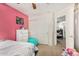 Bedroom with a pink accent wall and a twin bed with a gray comforter at 942 S Deerfield Ln, Gilbert, AZ 85296