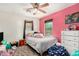 Bedroom with a pink accent wall, a twin bed, and a rainbow patterned rug at 942 S Deerfield Ln, Gilbert, AZ 85296
