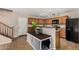 Well-lit kitchen with wood cabinetry and modern appliances, next to a staircase and a dog crate at 942 S Deerfield Ln, Gilbert, AZ 85296
