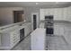 Spacious kitchen with white cabinetry, tiled countertops, stainless steel appliances, and large island at 955 W Laurel Ave, Gilbert, AZ 85233