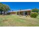 Expansive backyard with lush lawn, mature trees, and covered patio space at 10513 W Roundelay Cir, Sun City, AZ 85351