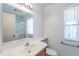 Bathroom with a green marbled countertop, wood cabinets, and a window at 10513 W Roundelay Cir, Sun City, AZ 85351