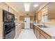 Well-lit kitchen featuring updated appliances, white tile floor, and ample storage space at 10513 W Roundelay Cir, Sun City, AZ 85351