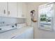 Laundry room featuring white cabinets, a window, and a washer and dryer at 10513 W Roundelay Cir, Sun City, AZ 85351