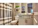 Bathroom featuring a vanity, decorated shelves, toilet, and striped shower curtain at 10643 E Tumbleweed Ave, Mesa, AZ 85212